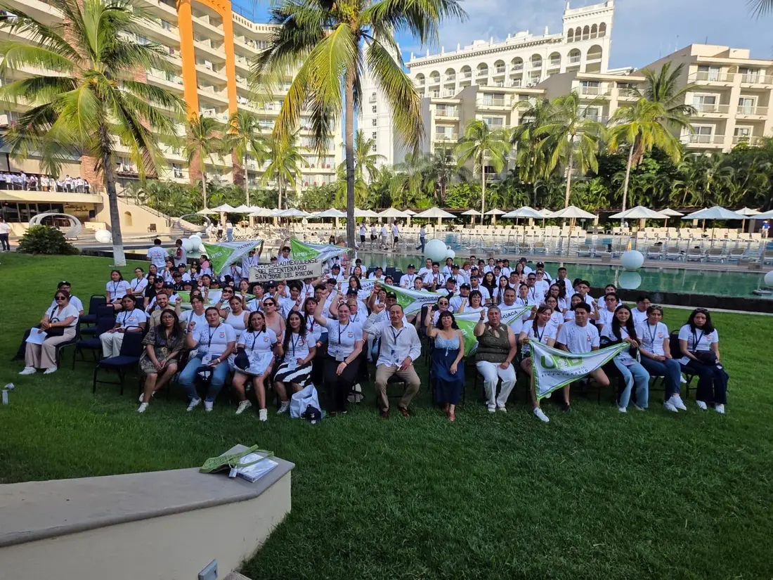 Foto grupal de los participantes del Programa Delfín 2026 al aire libre, con banderas de sus universidades.
